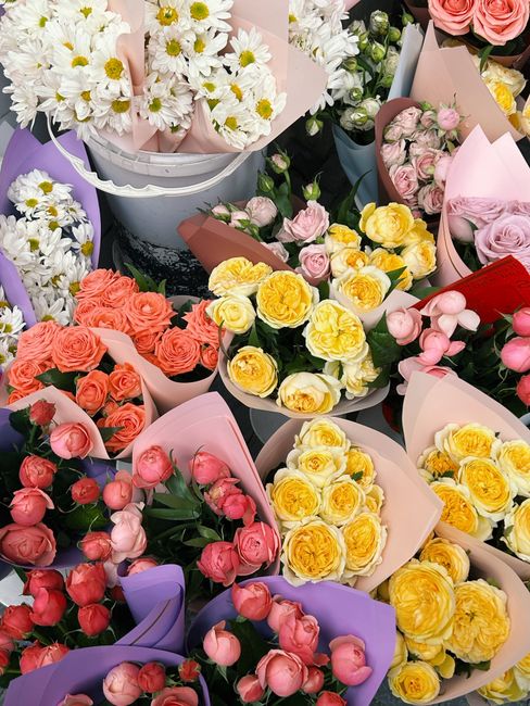 A vibrant display of various floral arrangements showcasing fresh flowers at southwoodfordflorist.co.uk. The image features bouquets of white daisies with yellow centers arranged in white baskets, alo